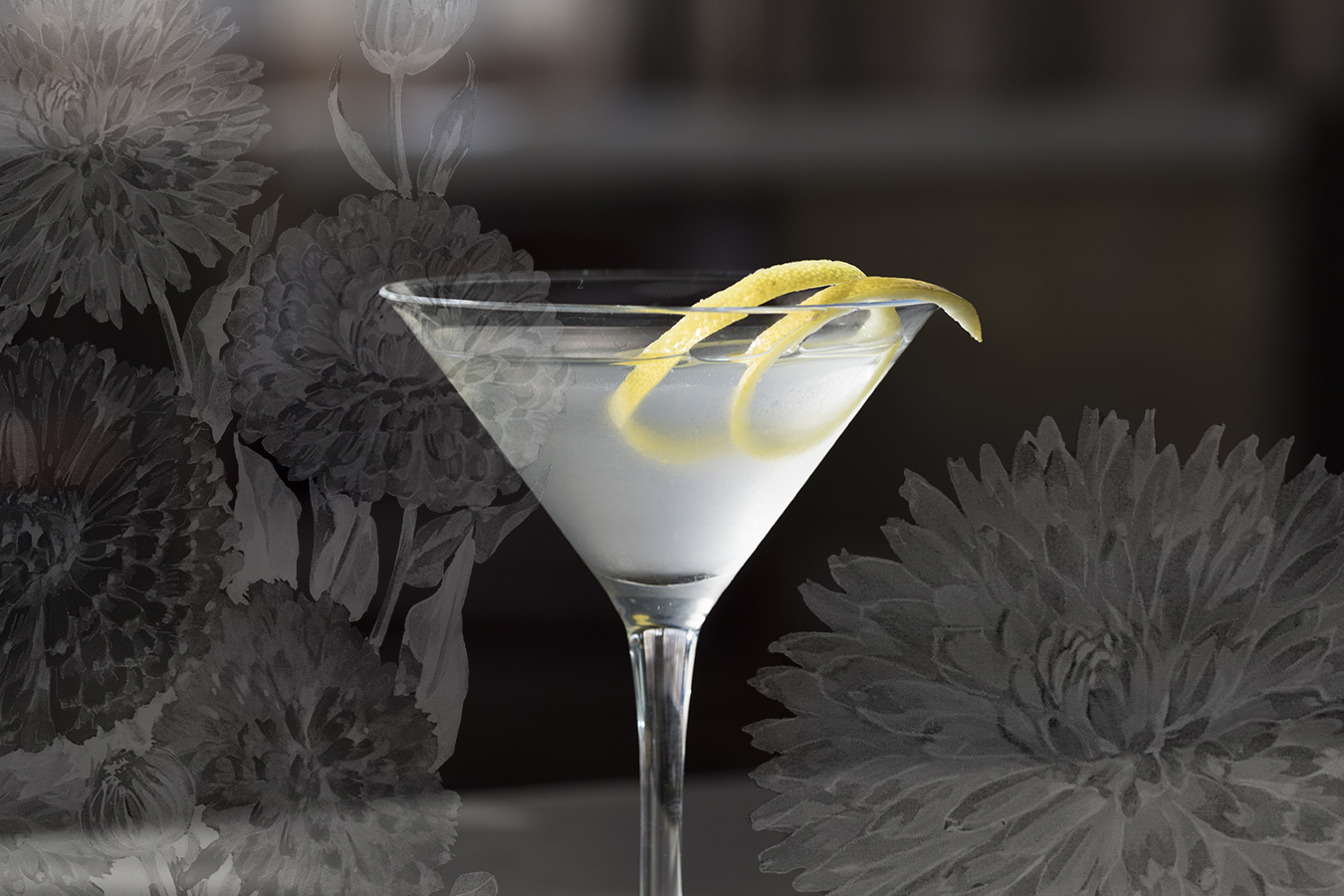 Photo of a martini glass with frosted liquid and a lemon twist, with a botanical illustration of marigolds in the background.